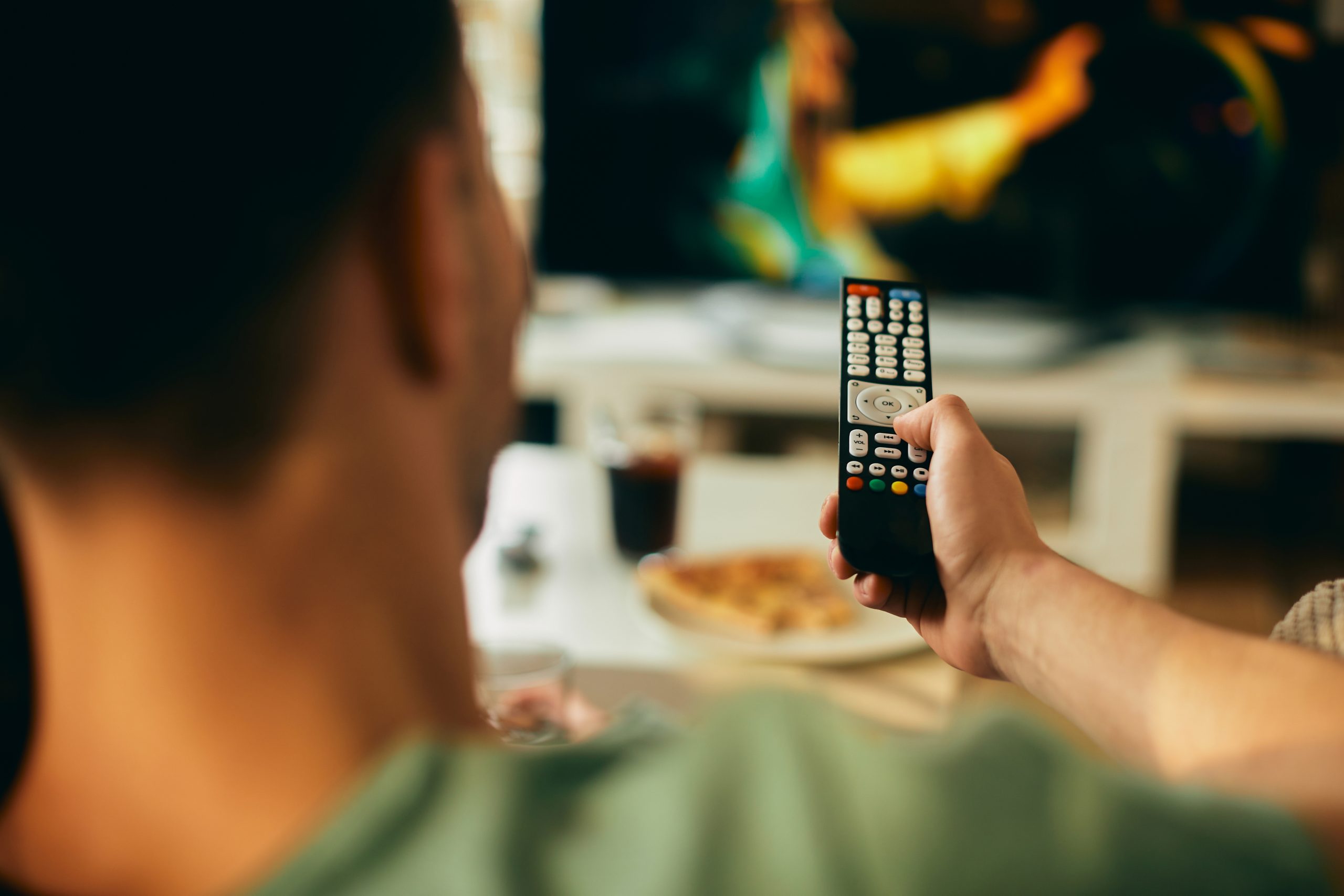 Close-up of man watching TV at home