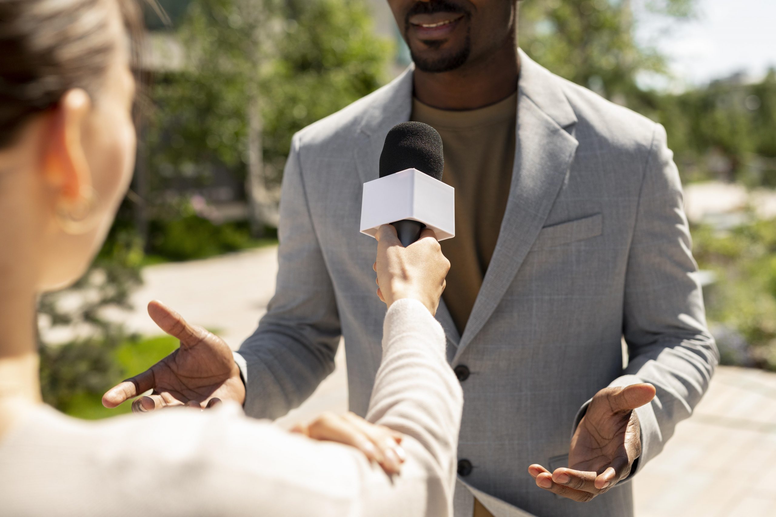 male-interviewed-by-journalists-outdoors